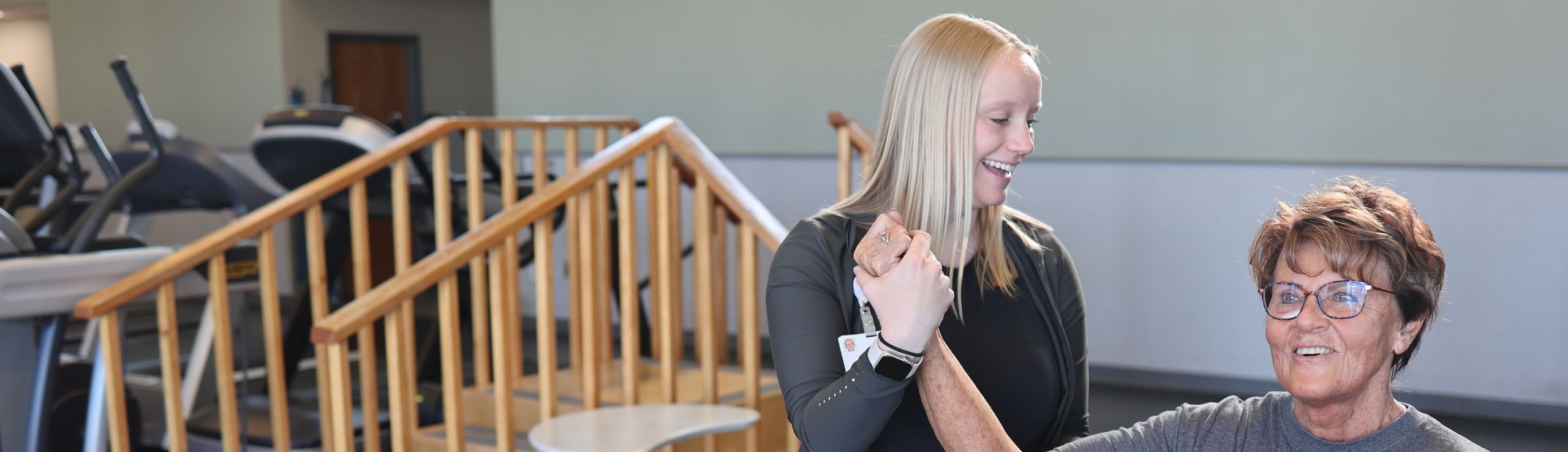 fizjoterapeuta pomaga dziecku w ćwiczeniach oddechowych z balonem w sali